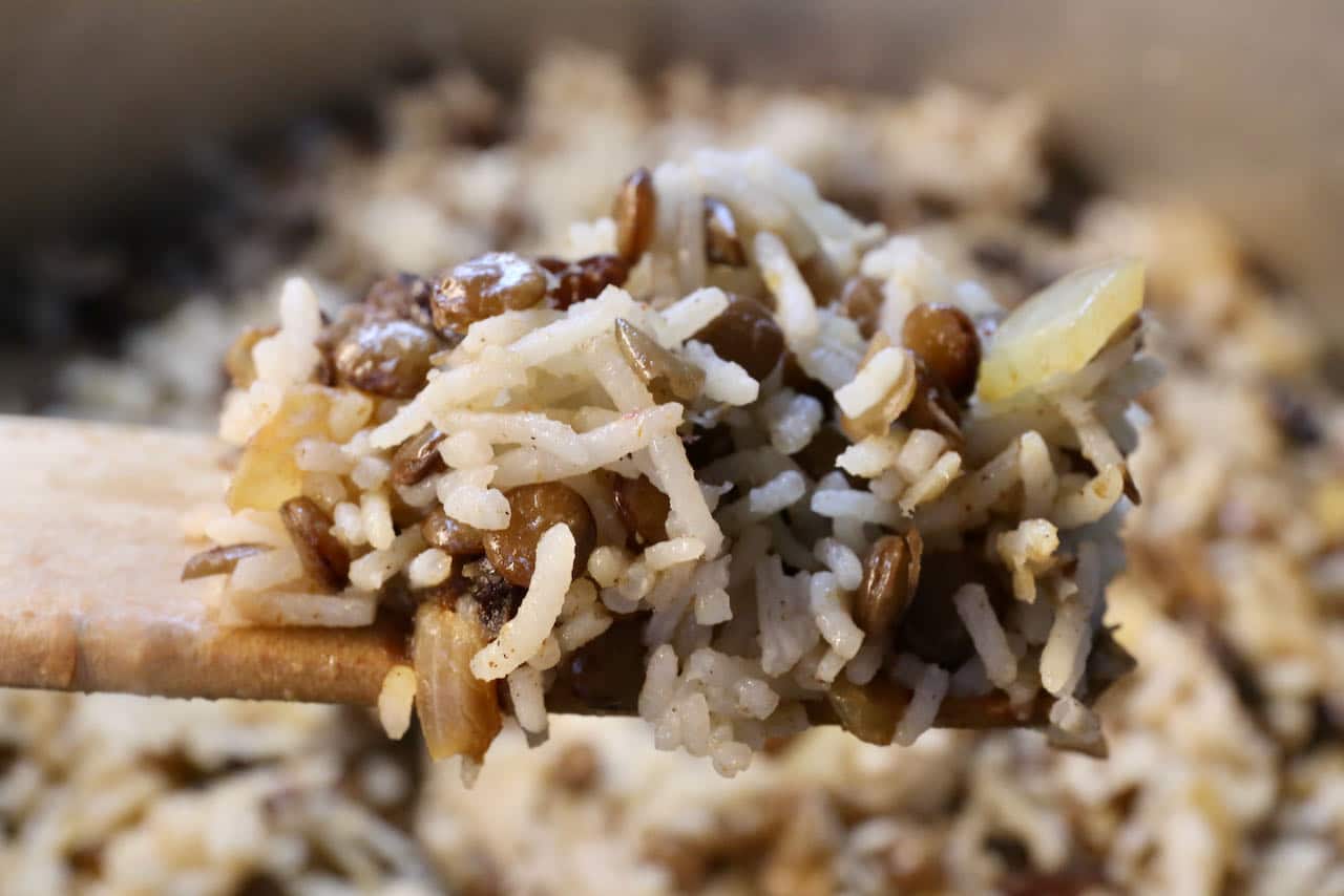 Scoop Persian Lentil Rice into a large serving bowl as a side dish at a Middle Eastern feast.