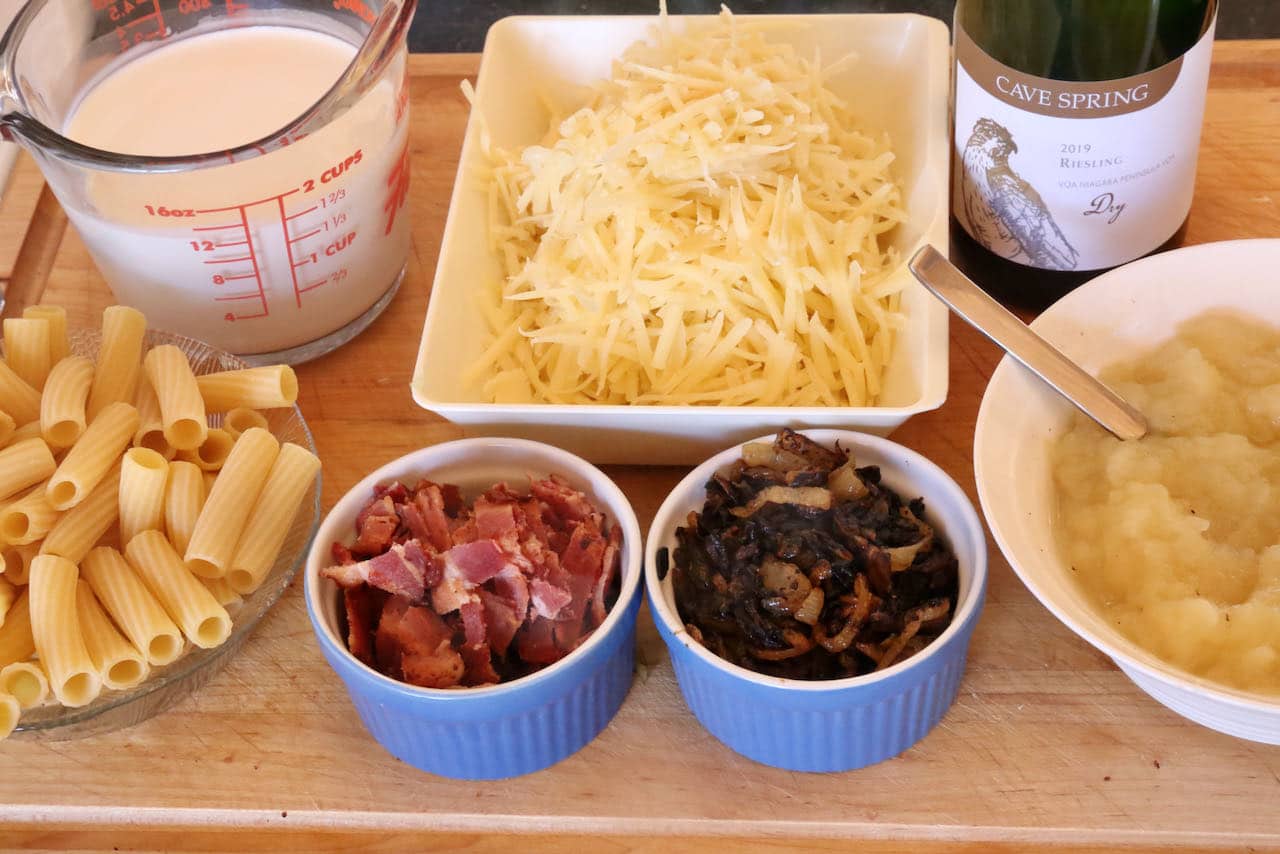 Authentic Aelplermagronen features Swiss macaroni pasta, cream, gruyere cheese, caramelized onions, bacon and applesauce.