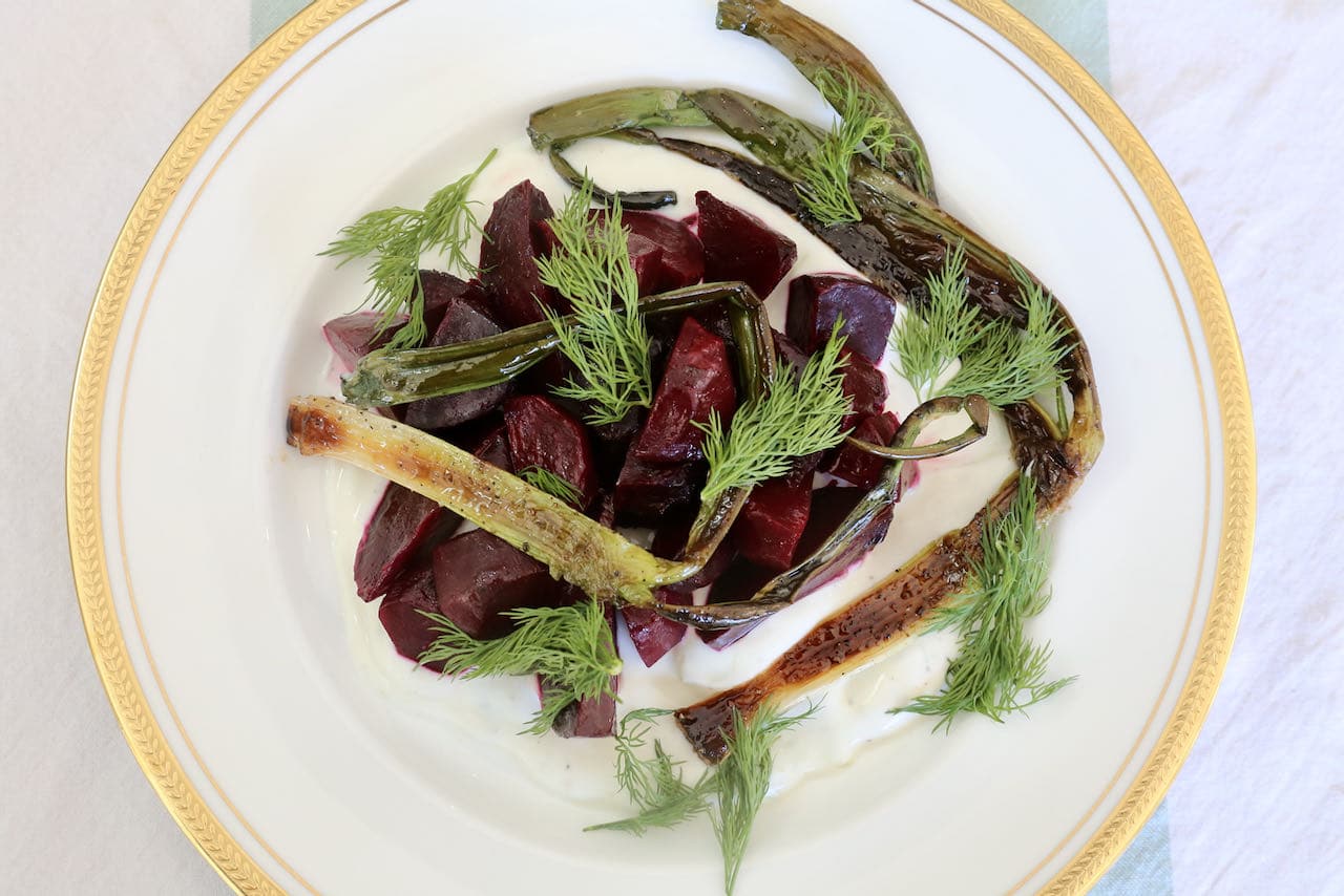 Beetroot Salad with Yogurt is garnished with sauteed scallions and fresh dill.