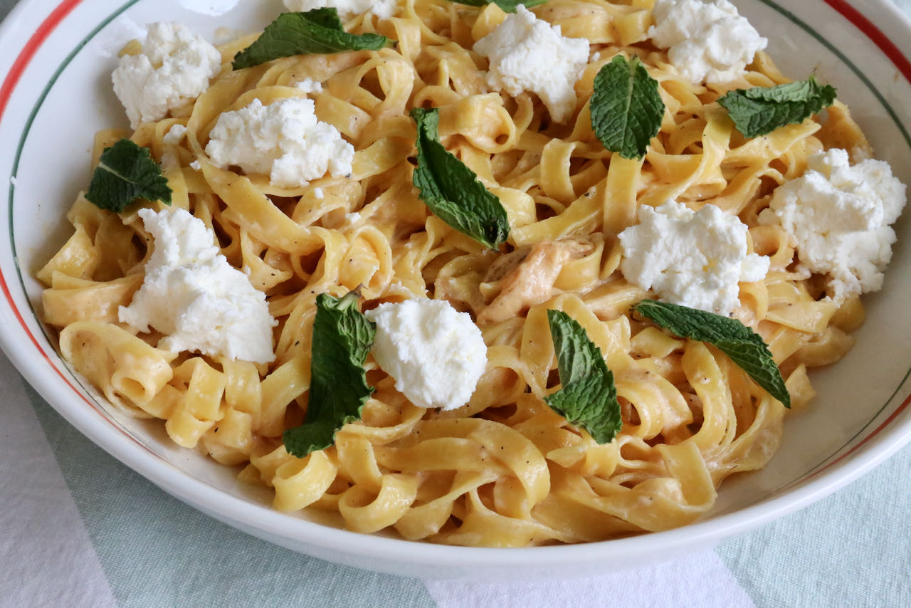 Our Saffron Pasta recipe is garnished with ricotta cheese and fresh mint leaves.