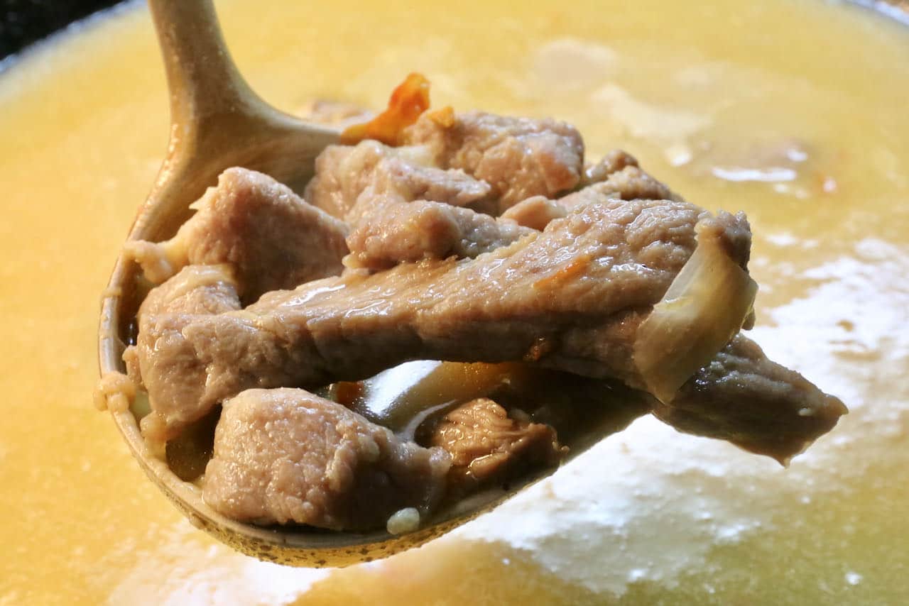 Ladle Burmese Coconut Noodle Soup broth into bowls. 