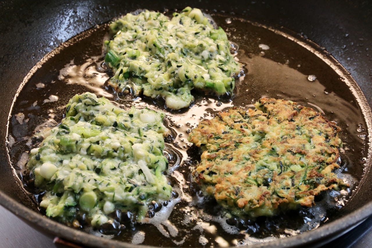 Shallow fry Mucver Tarif Turkish Zucchini Fritters until crispy and browned on both sides.