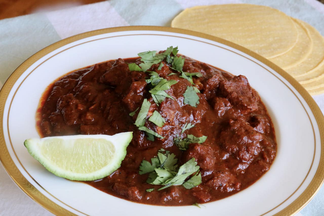Serve Asado de Boda with cilantro, lime and corn tortilla.