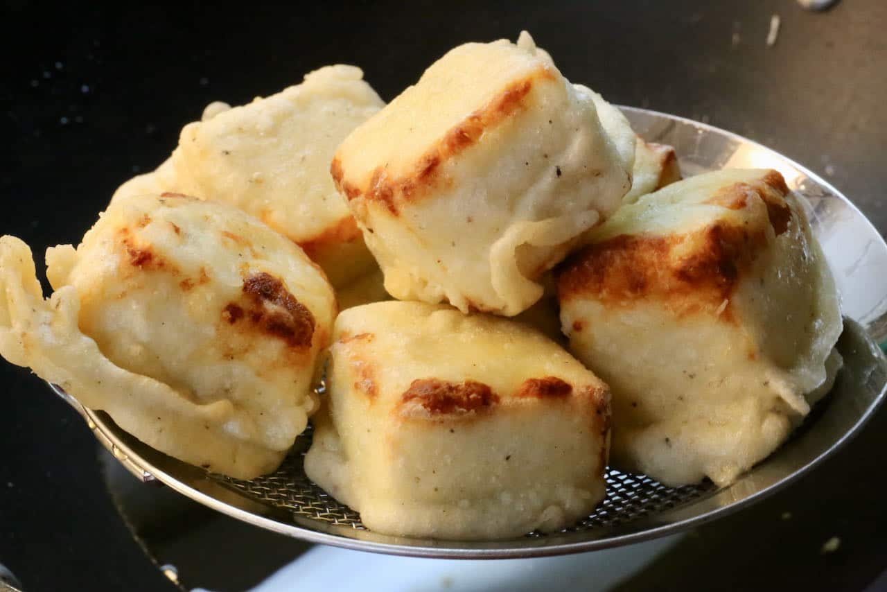Deep fry paneer cubes in oil until browned and crispy.