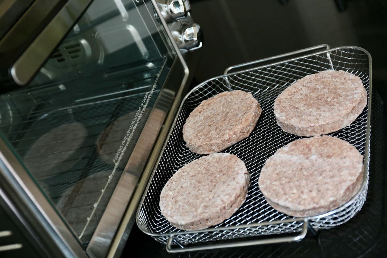 Cook frozen burger patties in an air fryer basket. 