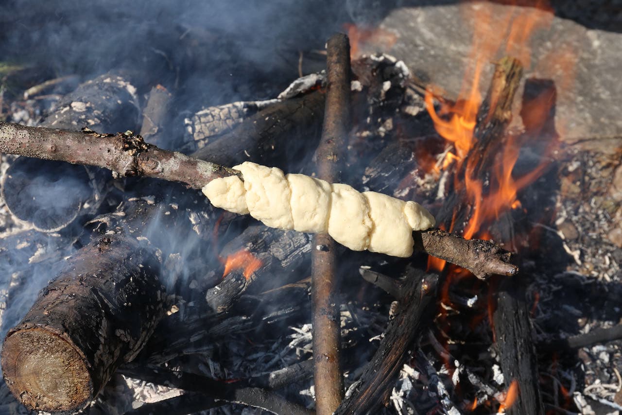 Gently rotate snobrod around bonfire embers. 