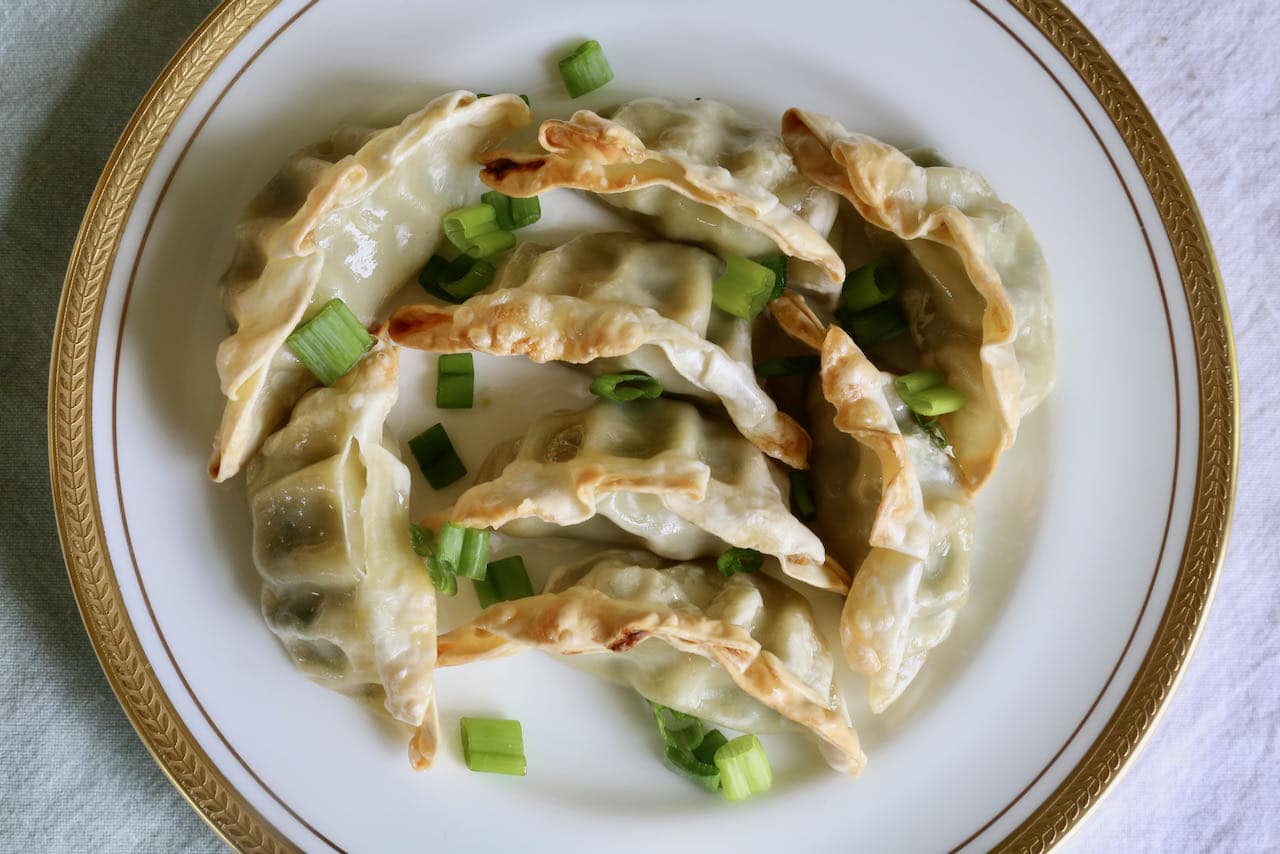 Serve Air Fryer Potstickers, Dumplings & Gyoza garnished with sliced scallions.