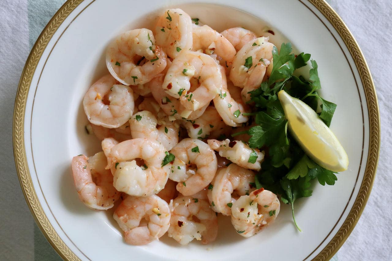 Serve Frozen Shrimp Cooked in an Air Fryer with fresh parsley and lemon slices.