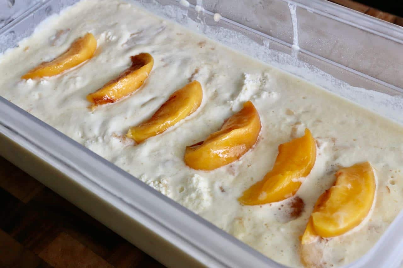Top ice cream with slices of fresh peach before freezing overnight. 