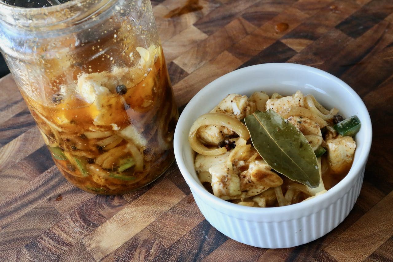 Serve Nakladany Hermelin in a bowl or ramekin as part of a cheese and charcuterie board.