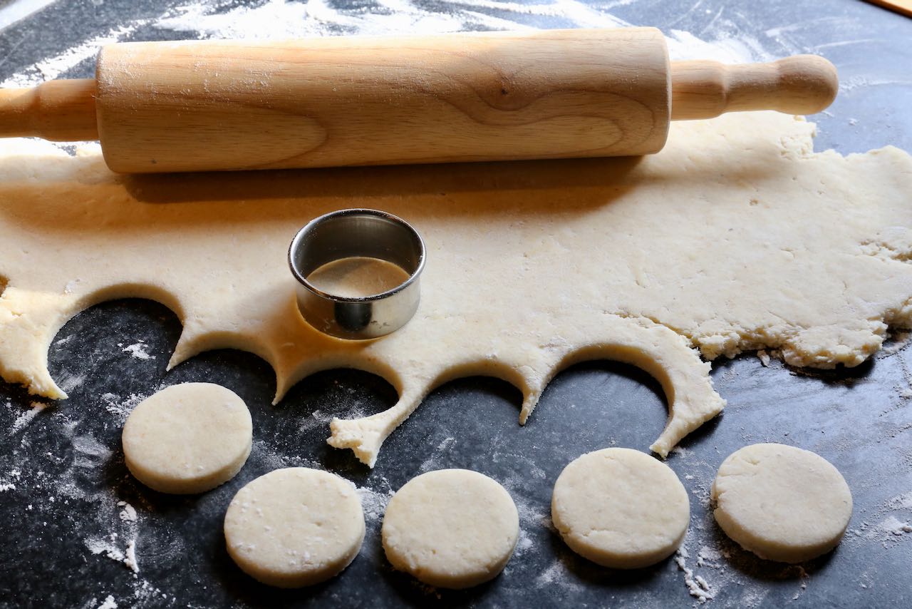 Roll out the Pogacsa dough then use a circular cookie cutter to make small biscuits.