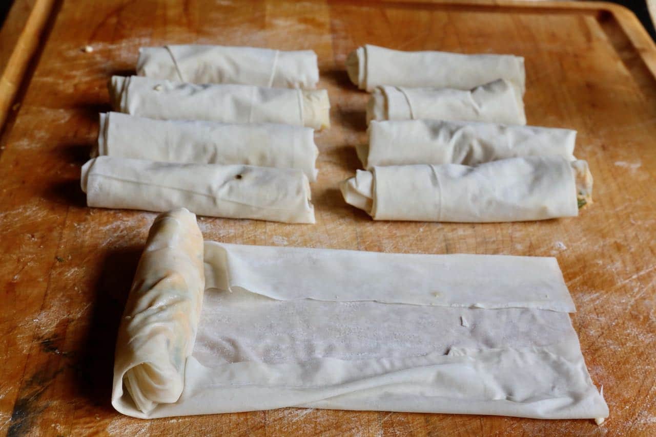 Fill filo sheet with cheese filling then roll into a cigar shape.