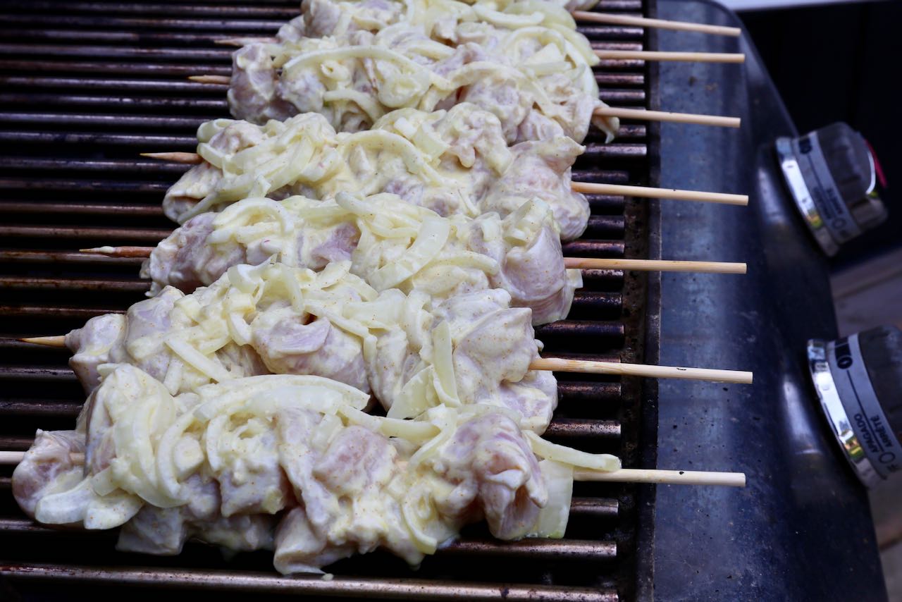 Grill Persian Yogurt Saffron Chicken Skewers on a hot barbecue grill.