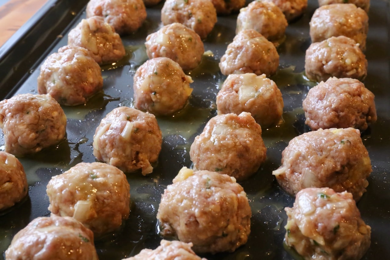 Roast Keftedakia on a baking tray in the oven.