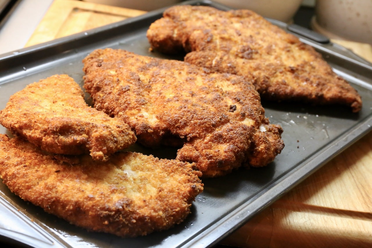 Fried Turkey Escalope resting on a baking sheet. 