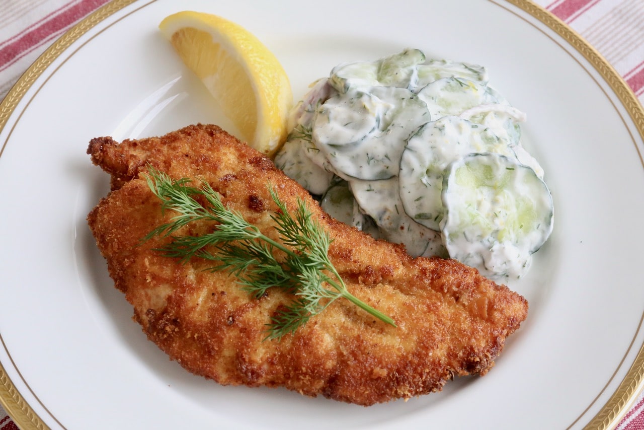 Garnish Kotlet z Indyka with a sprig of fresh dill.