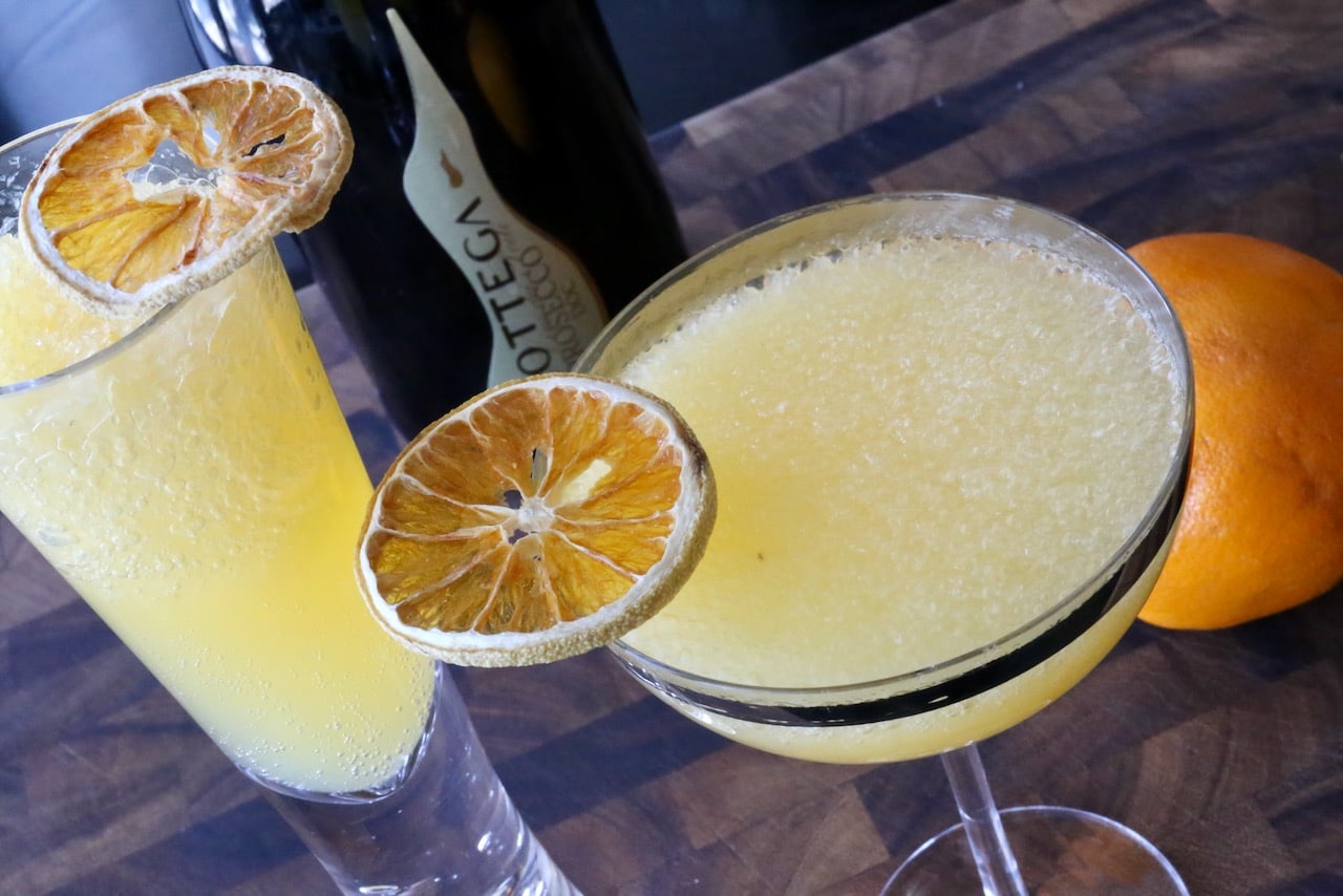 Frozen Mimosas are prepared by blending champagne with orange juice frozen in ice crube trays.