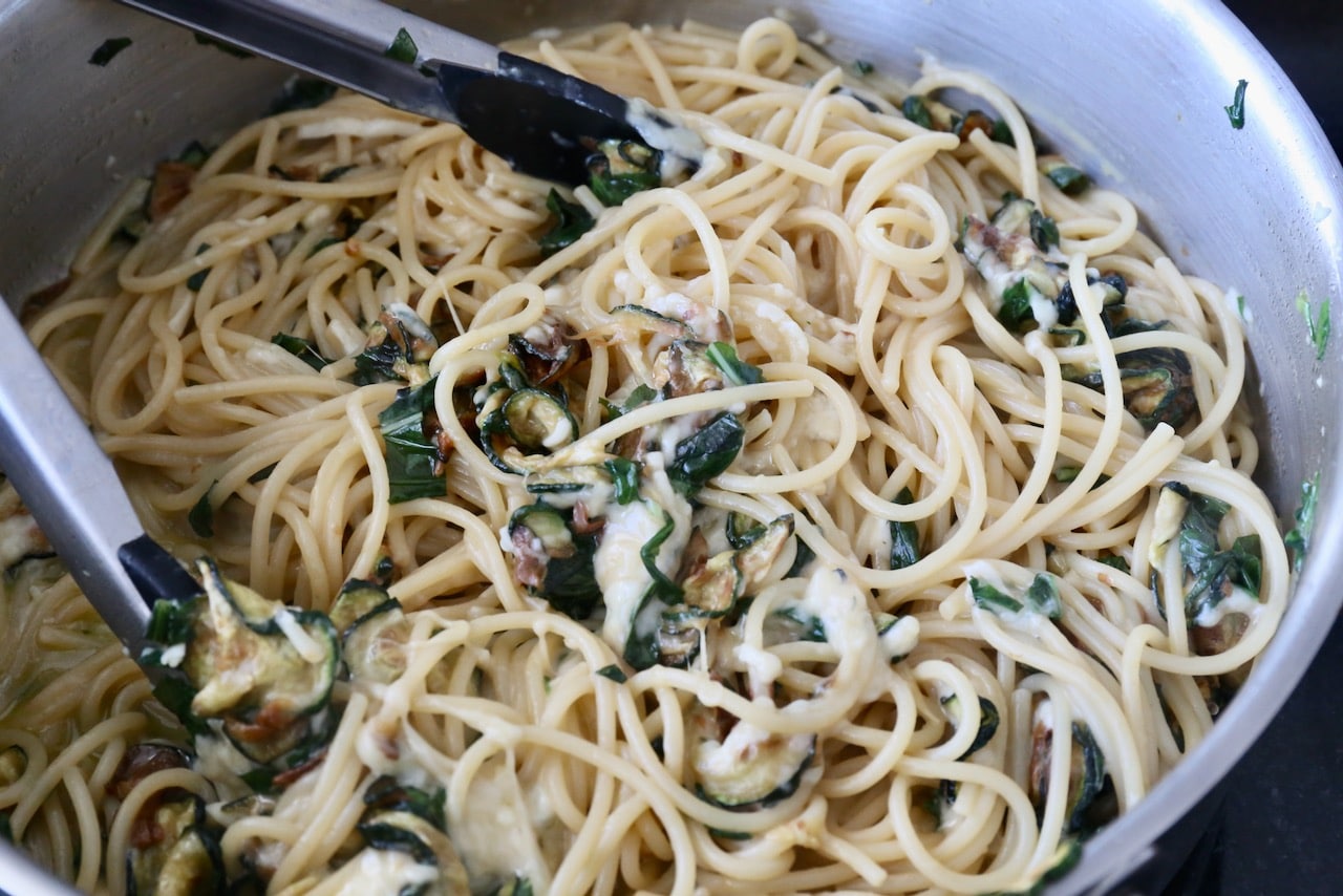 Use tongs to toss Spaghetti con Zucchine until you create a creamy sauce.