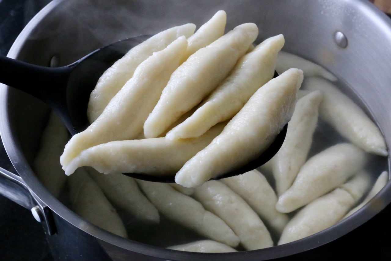 Boil Mohnnudeln in a large pot until the dumplings float to the top of the simmering water.
