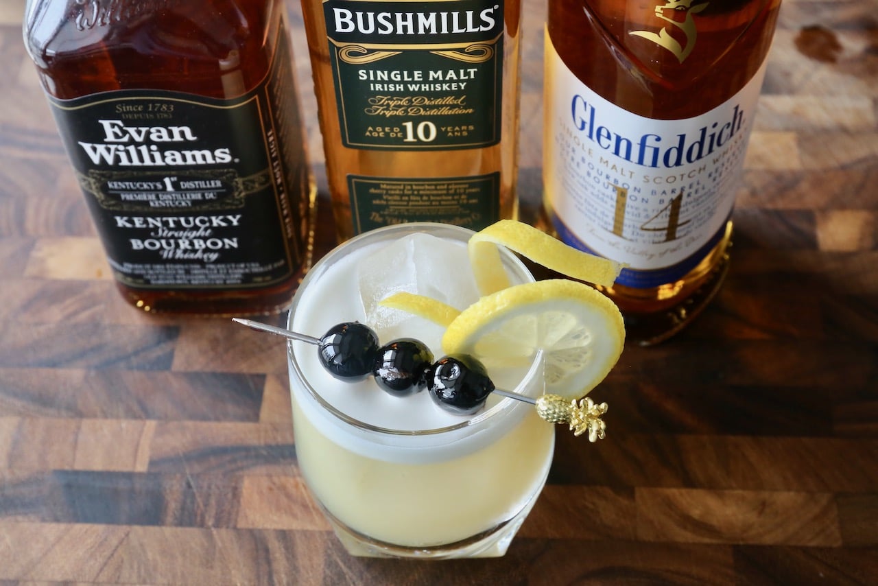 Garnish a Boston Sour with lemon twist and maraschino cherry cocktail skewer.