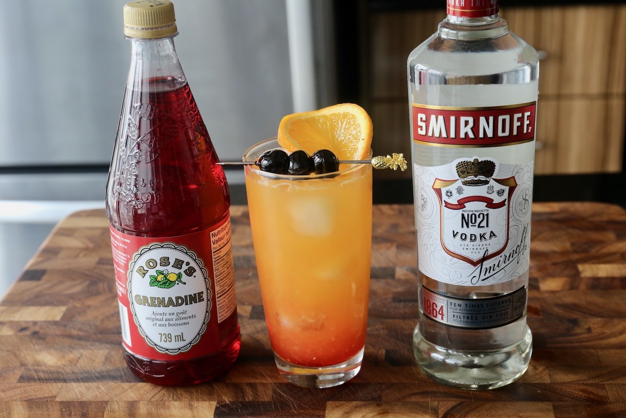 Garnish a Vodka Sunrise with an orange slice and cocktail skewer with cherries.