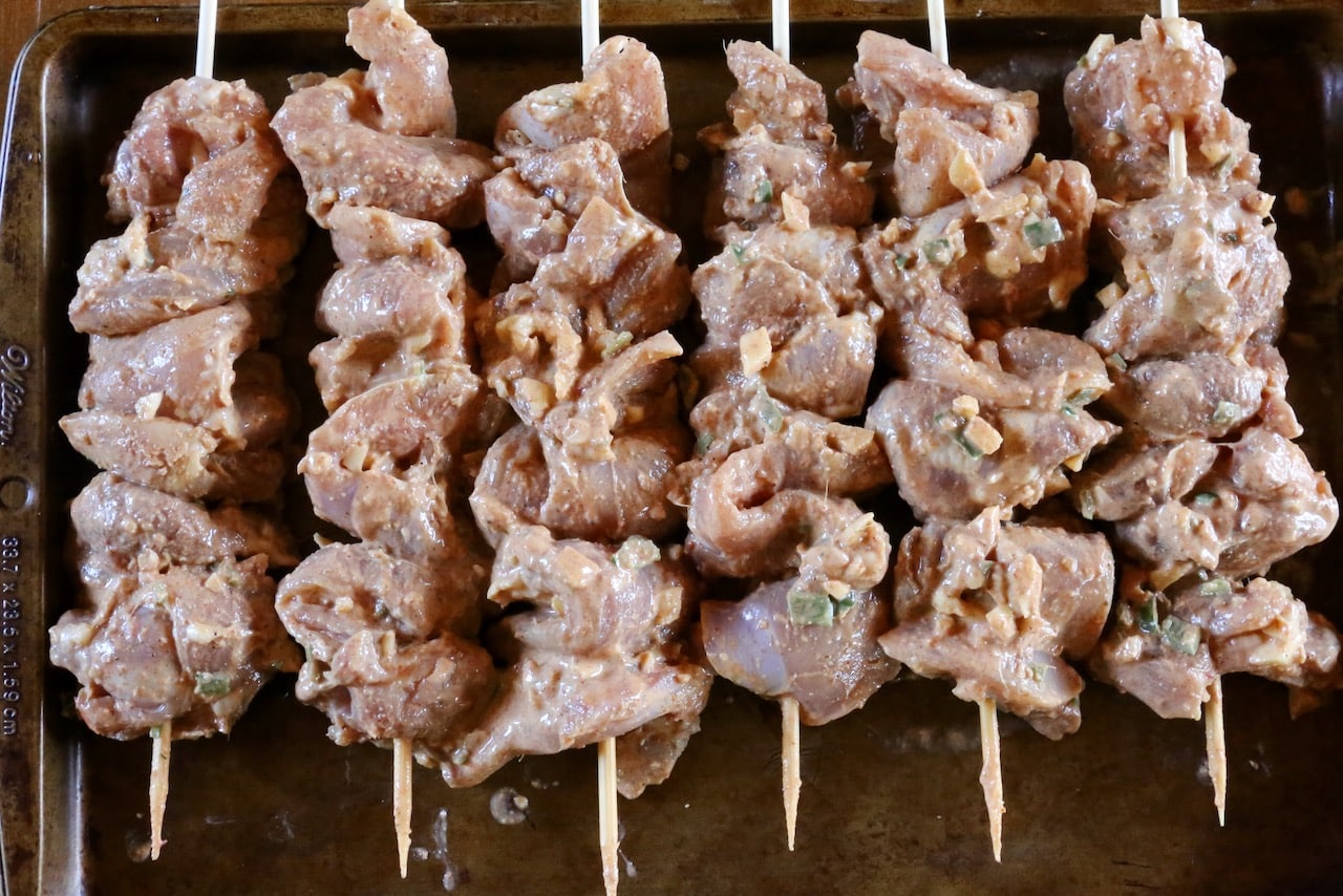 Slide chunks of marinated chicken onto barbecue skewers. 