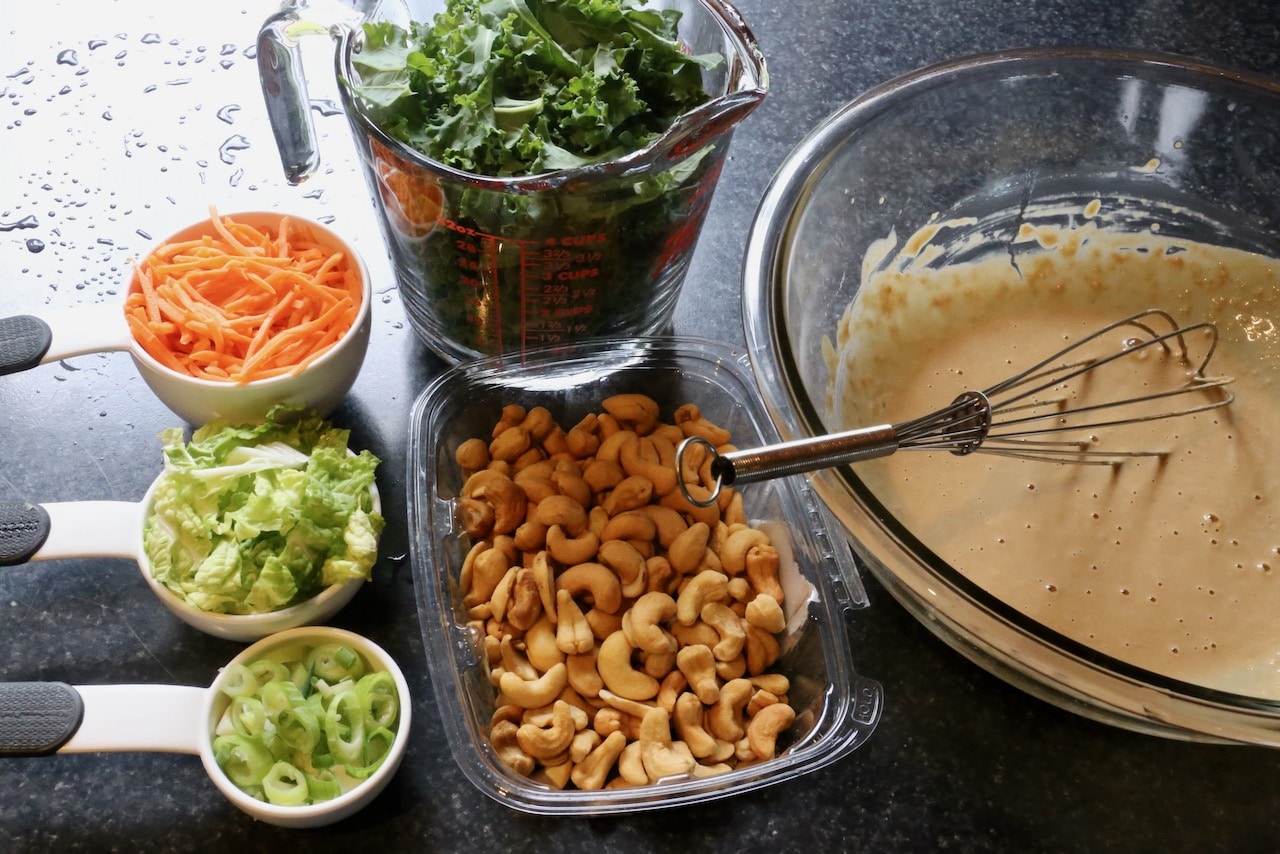 Whisk Miso Tahini Dressing in a mixing bowl then toss with kale, cabbage, scallions, carrots and cashews. 