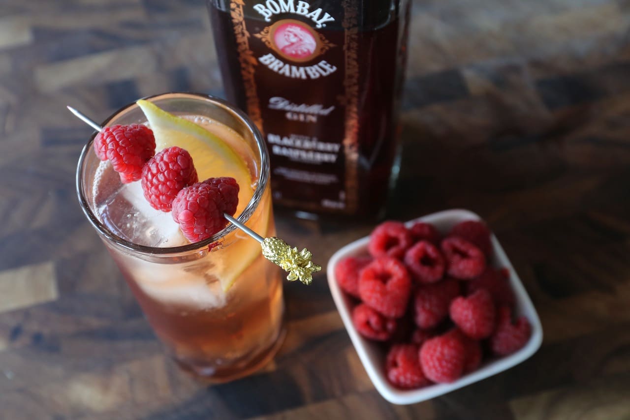 Garnish this Bombay Bramble Cocktail recipe with a raspberry skewer.