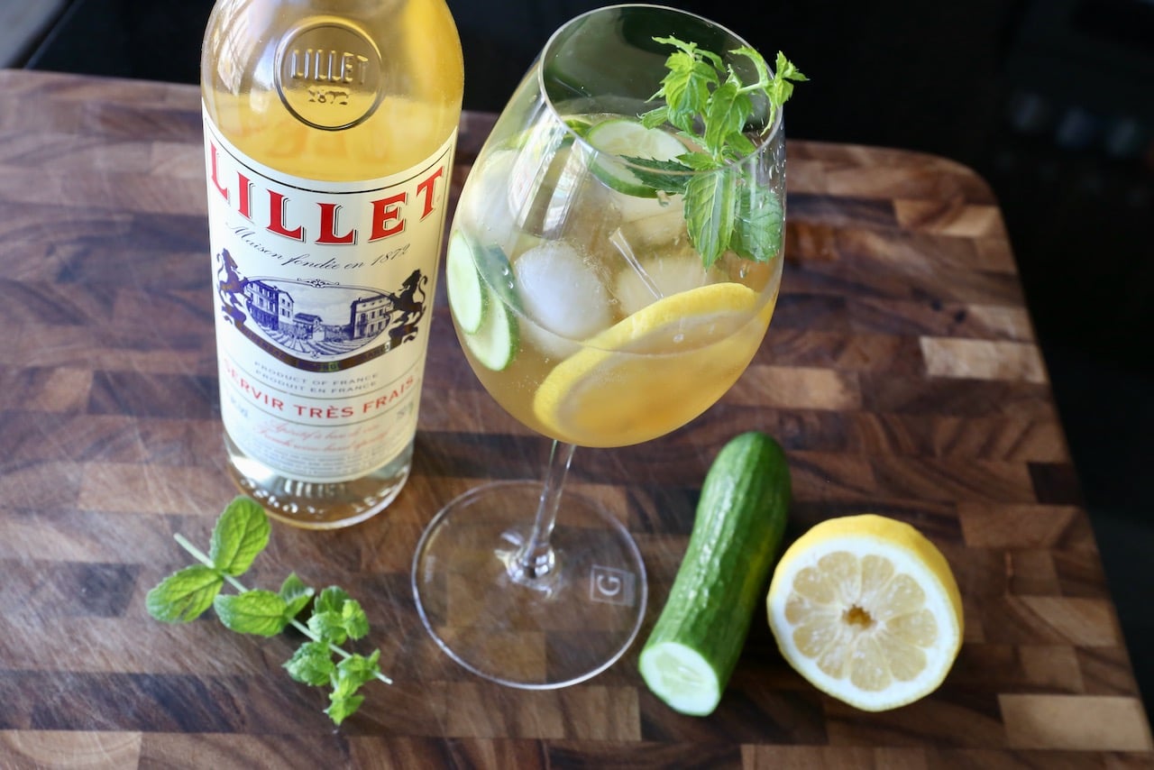 Muddle a Lillet Spritz Cocktail with sliced cucumber, lemon wheels and fresh mint sprig.