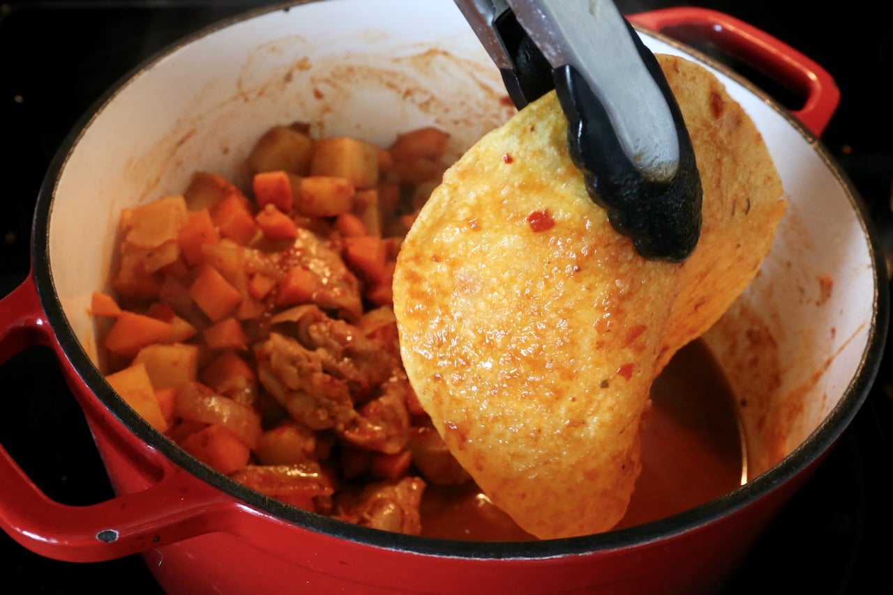 Using tongs dip the corn tortillas in the sauce. 