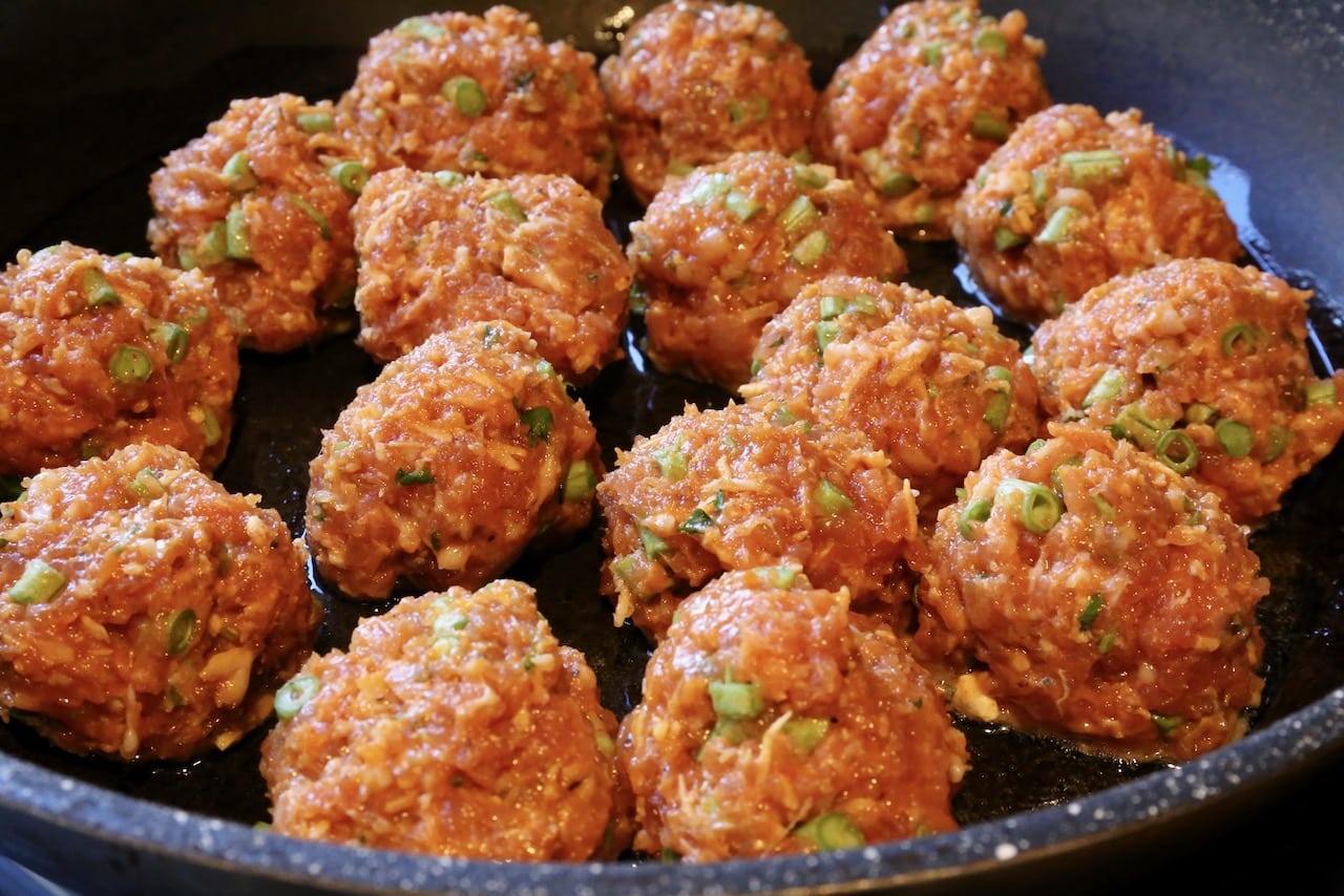 Pan-fry Thai Curry Pork Meatballs in a large skillet.