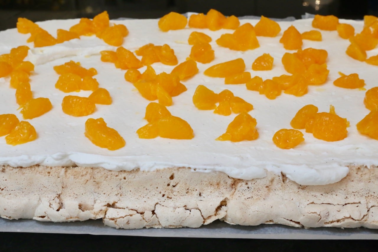 Slather baked meringue with whipping cream and top with mandarin orange segments.