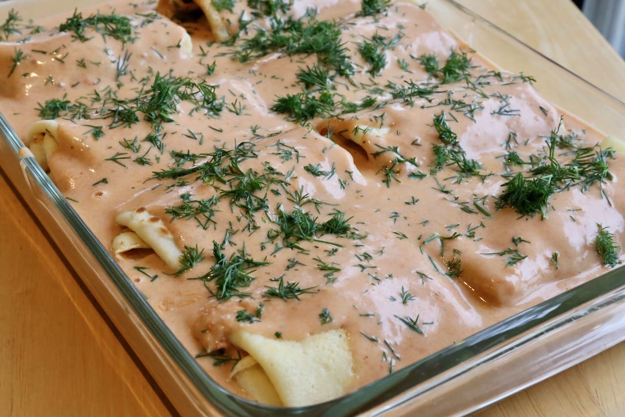 Cover stuffed crepes with the remaining sauce and finely chopped dill. 