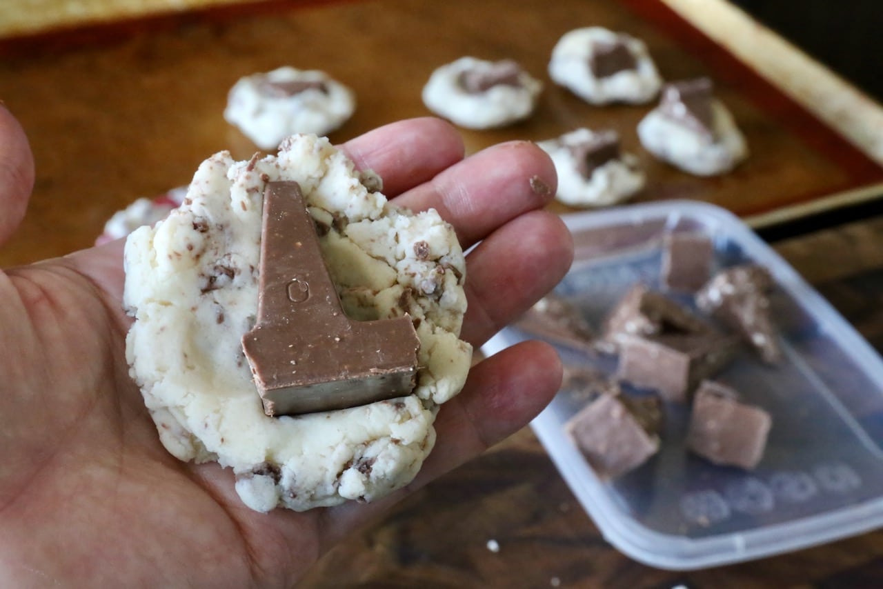 Stuff shortbread cookie dough with a piece of Toblerone chocolate before baking.