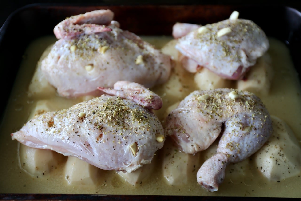 Sprinkle the chicken pieces with oregano then bake over potatoes in a hot oven.