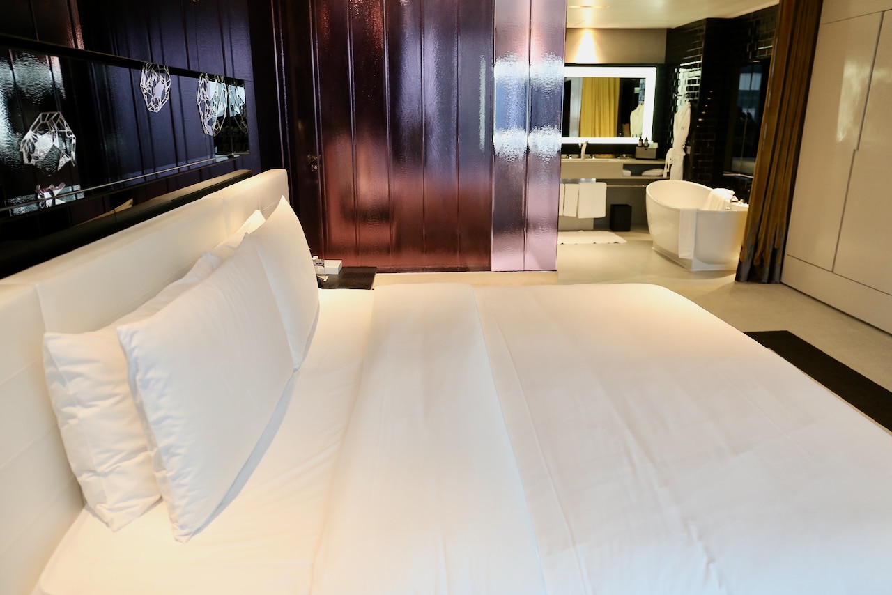 A big comfy bed overlooks a luxurious bath tub at W Bangkok's Marvelous Suite.