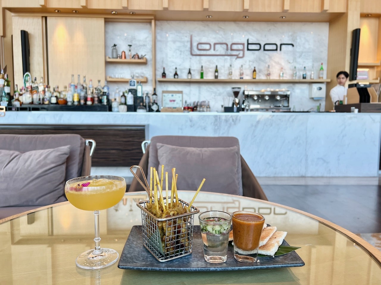 Sip cocktails and nosh on satay skewers at Long Bar. 