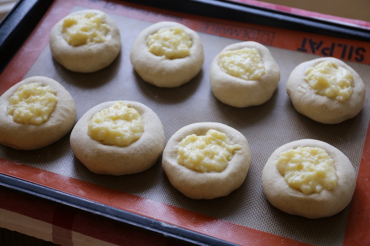 Form 12 buns using leavened yeast dough then fill with pastry cream.