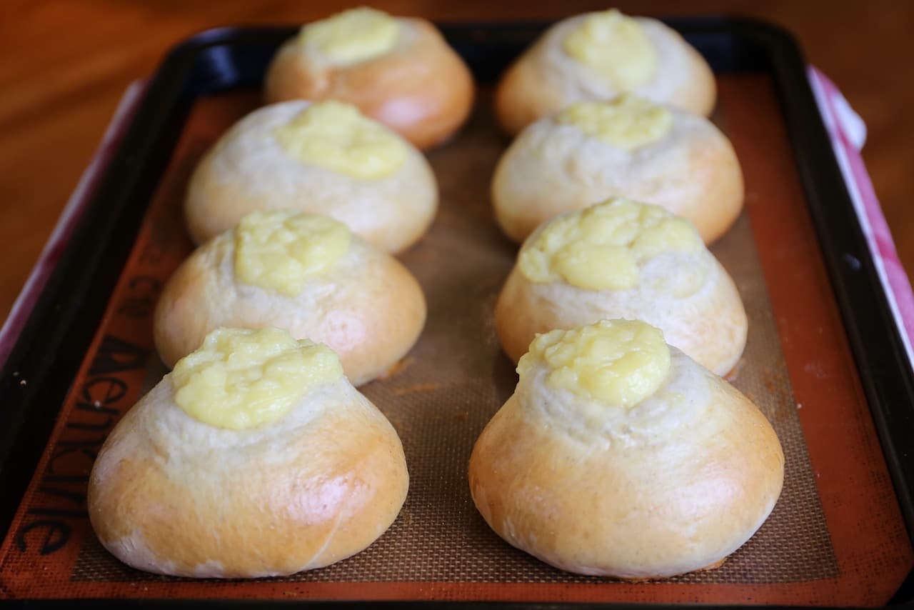 Bake Norwegian Custard Coconut Buns until the bread has lightly browned and dough has bloomed in the oven. 
