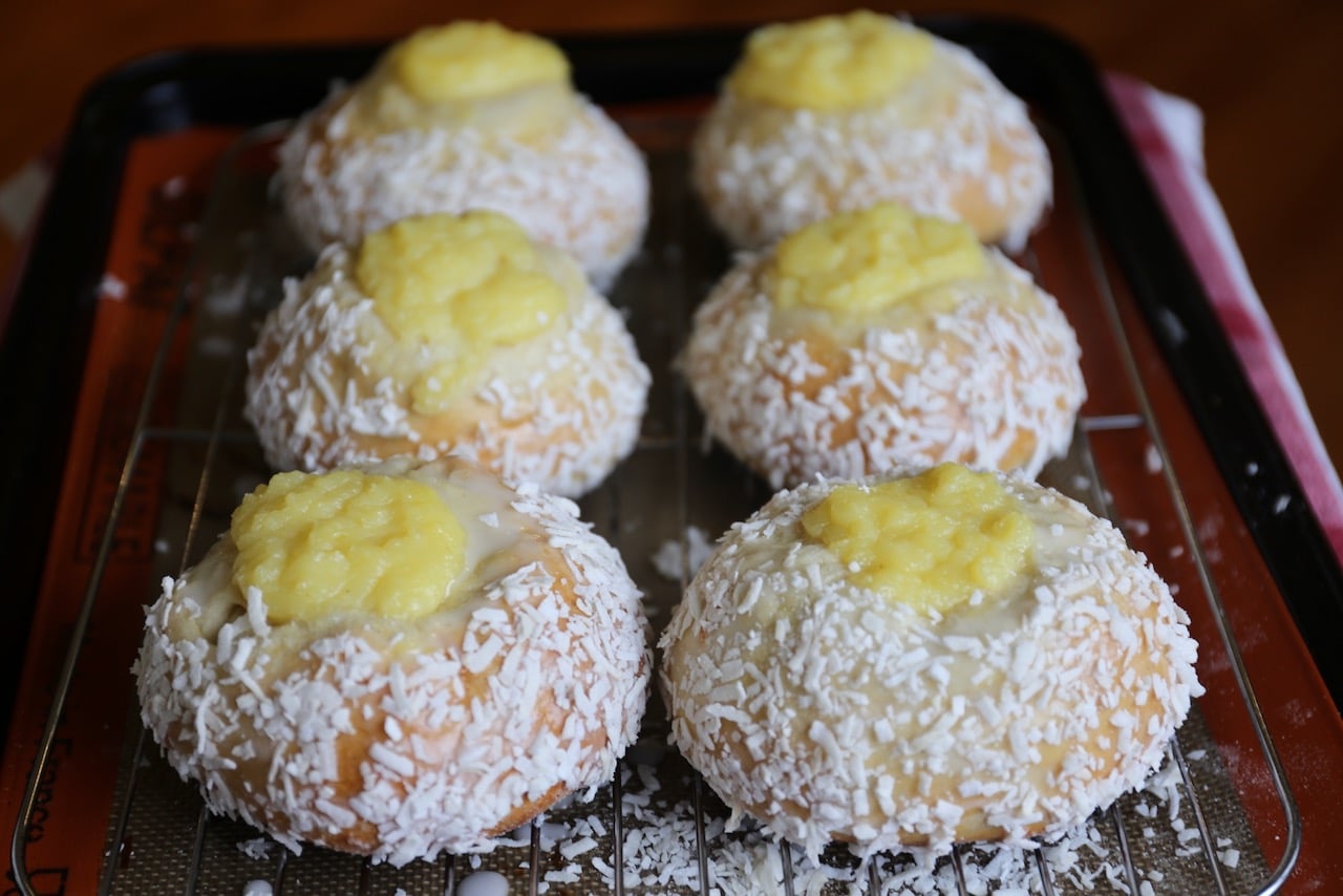 Roll buns in shredded coconut then allow to rest on a cooling rack.