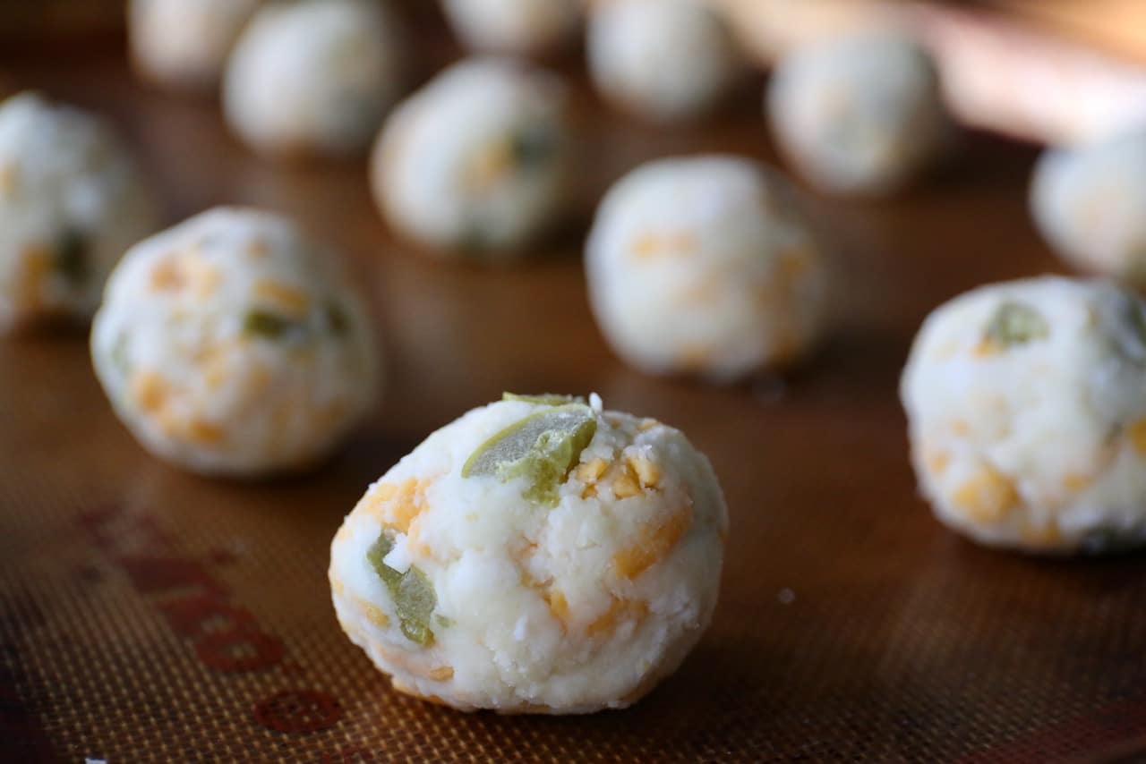 Using wet hands, roll cheese puffs into the size of golf balls. 