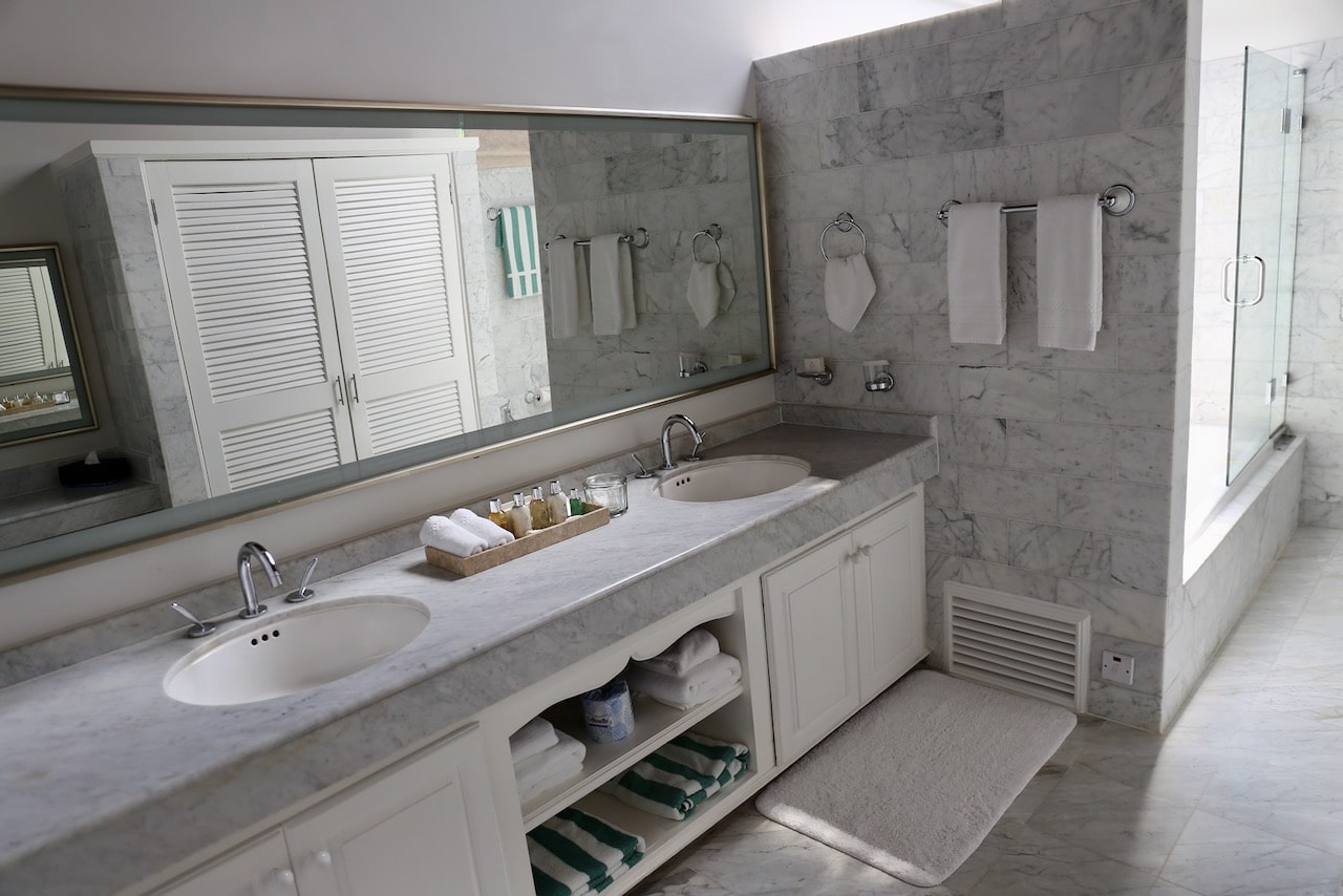 Chic white marble bathrooms are outfitted with Molton Brown bath amenities.
