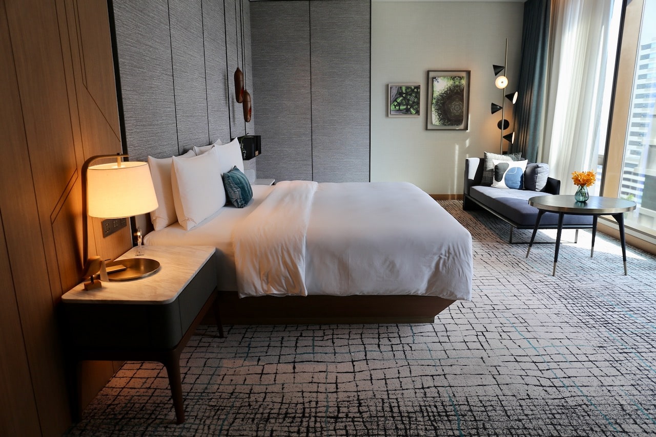 A stylish bedroom in a suite at Kimpton Maa-Lai.