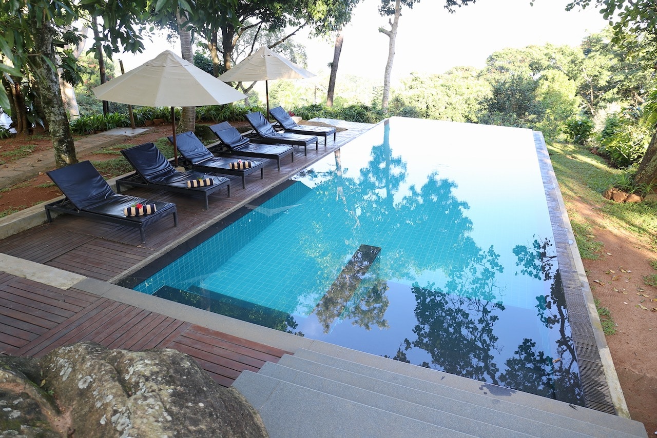 The infinity pool overlooks a tea plantation and mountains.