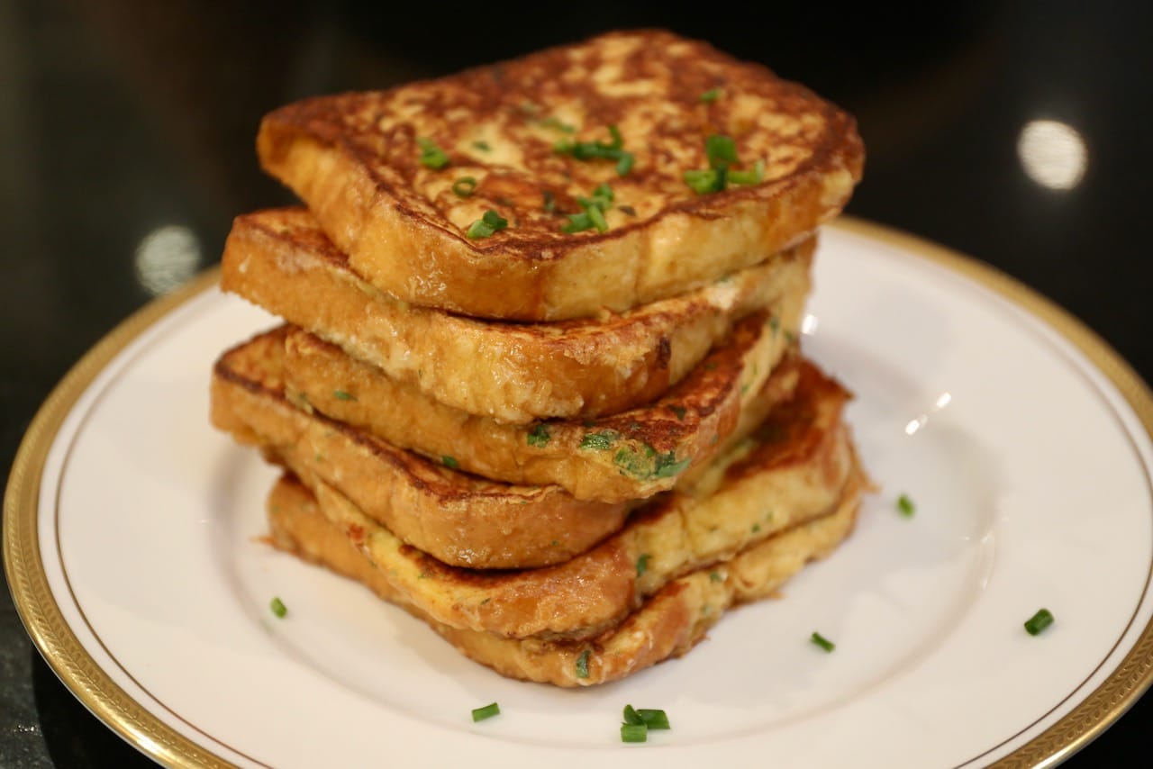 A stack of Savory French Toast topped with finely chopped chives.