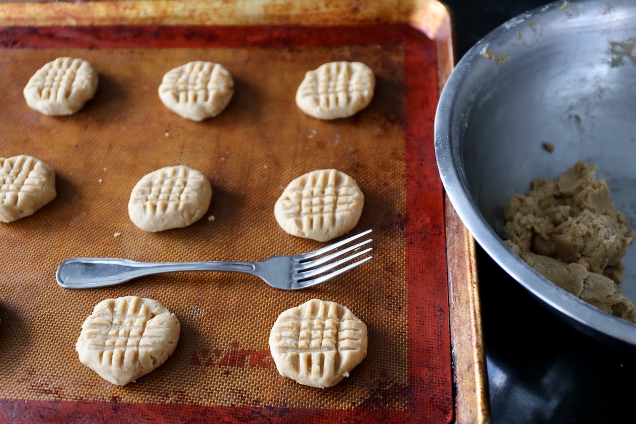 Score the top of each cookie with a criss cross patter by pressing the dough with a fork.