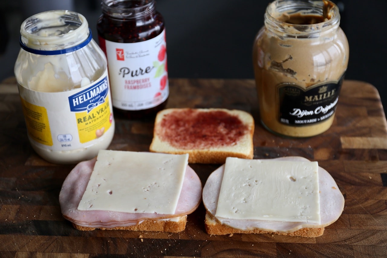 This triple decker sandwich features brioche bread, ham, turkey, Swiss cheese, dijon mustard and raspberry jam.