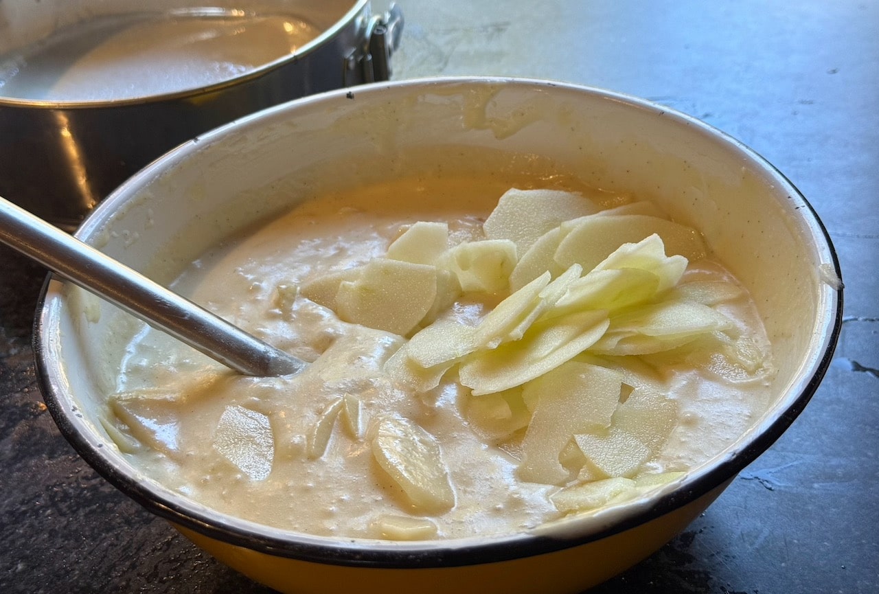 Combine sliced pears and apples in a mixing bowl with cake batter.